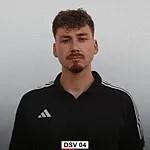 Portr&auml;t eines Mannes mit lockigem Haar, schwarzem Shirt und neutralem Hintergrund. Er schaut direkt in die Kamera.